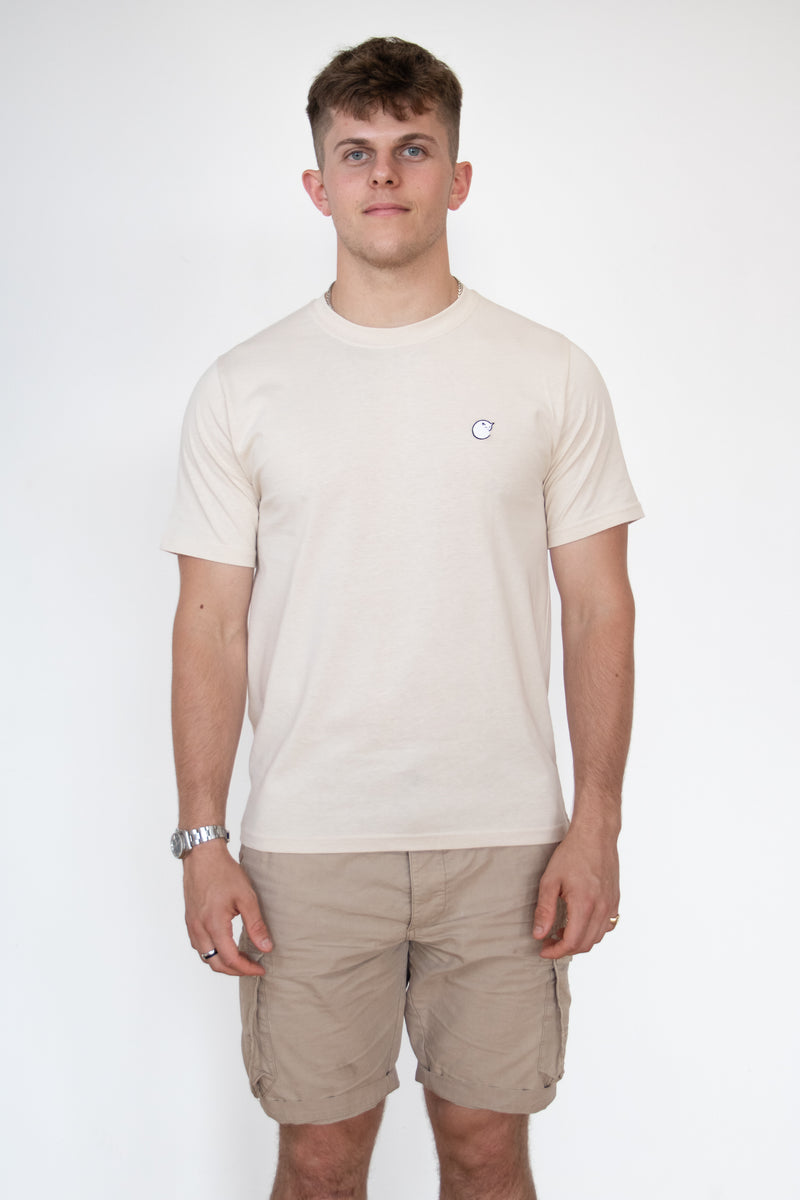 Front view of a male model wearing a cream cosycore by beCosy short sleeve tshirt with an embroidered cat logo