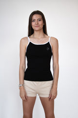 Front view of female model wearing a black cosycore tank top with embroidered cat logo showing off the figure flattering fit