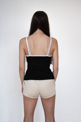 back view of female model wearing a black cosycore tank top with embroidered cat logo showing off the figure flattering fit