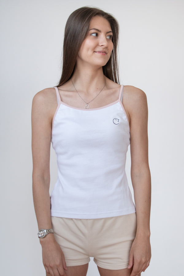 Front view of female model wearing a whitecosycore tank top with embroidered cat logo showing off the figure flattering fit
