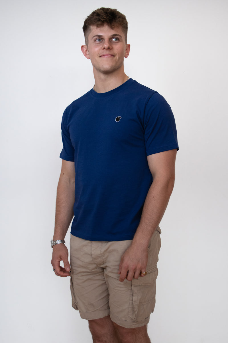 A side on view of a male model wearing a navy blue cosycore by beCosy short sleeve tshirt with an embroidered cat logo