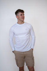 Front view of a male model wearing a white long sleeve cosycore tshirt by beCosy with an embroidered cat logo
