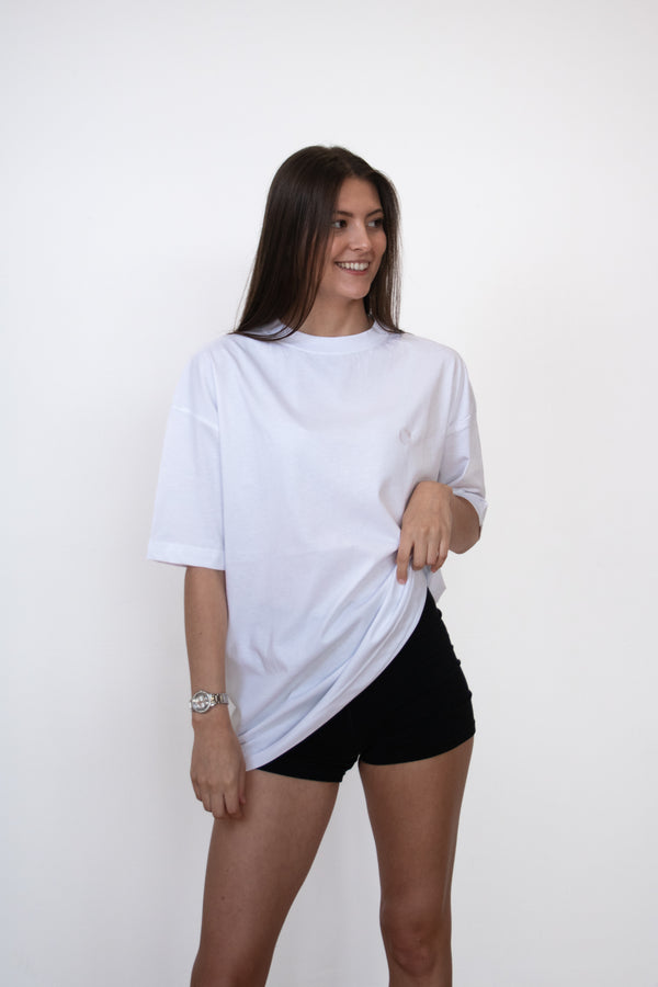 front view of female model wearing a white cosycore by becosy oversized womens tshirt with embroidered logo