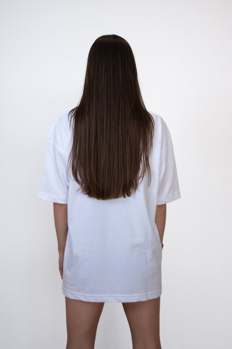 Back view of female model wearing a white cosycore by becosy oversized womens tshirt with embroidered logo
