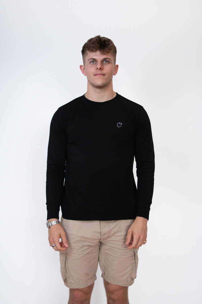 Front view of a male model wearing a black long sleeve cosycore tshirt by beCosy with an embroidered cat logo