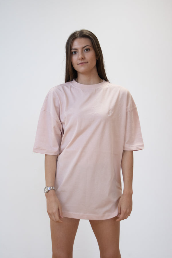 front view of female model wearing a blush pink cosycore by becosy oversized womens tshirt with embroidered logo